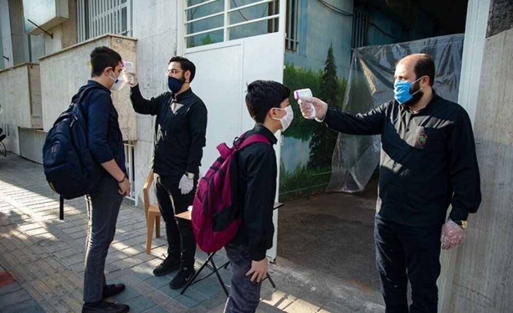 コロナ流行当初のテヘラン市内のある男子中学校の登校時の様子。校舎に入る前に生徒１人１人を検温